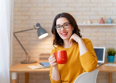 İnternette ders çalışan, Webinar izleyen, dizüstü bilgisayarda podcast yapan notlar alan, çalışma masasında oturan genç bir iş kadını. E-öğrenme kavramı.