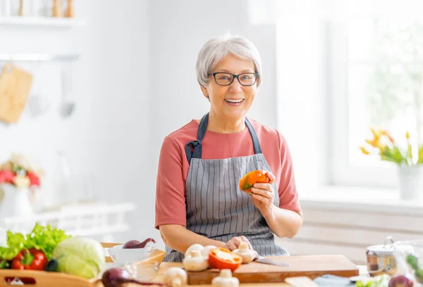 家庭での健康食品 幸せな女性は台所で野菜や果物を準備しています — ストック写真