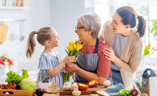 Glückliche Familie Der Küche Enkelin Schenkt Ihrer Großmutter Blumen — Stockfoto