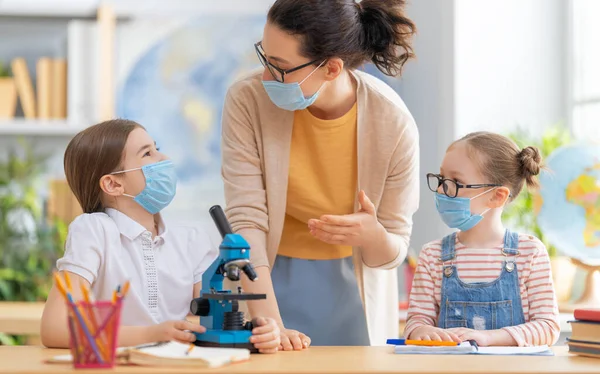 Zurück Zur Schule Glückliche Kinder Sitzen Mit Gesichtsmasken Schreibtisch Mädchen — Stockfoto