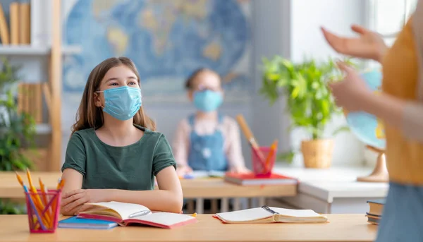 Zurück Zur Schule Glückliche Kinder Sitzen Mit Gesichtsmasken Schreibtisch Mädchen — Stockfoto