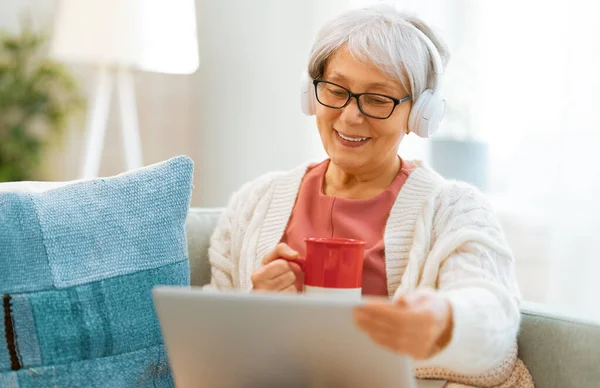 Fröhliche Schöne Seniorin Sitzt Mit Laptop Hause Auf Dem Sofa — Stockfoto