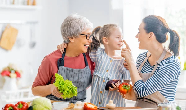 家庭での健康食品 キッチンで幸せな家族 おばあちゃん お母さん お子さんが野菜を作っています — ストック写真