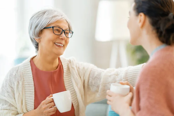 Schöne Mutter Und Tochter Reden Und Lächeln Während Sie Hause — Stockfoto