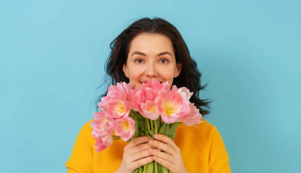 Vacker Ung Kvinna Med Rosa Blommor Tulpaner Händerna Blå Vägg — Stockfoto