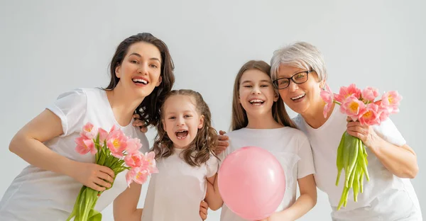 幸せな女性の日 子供たちの娘たちは お母さんとおばあちゃんが花のチューリップを与えてくれることを祝福しています 家族の休日と友情 — ストック写真