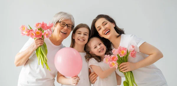 幸せな女性の日 子供たちの娘たちは お母さんとおばあちゃんが花のチューリップを与えてくれることを祝福しています 家族の休日と友情 — ストック写真