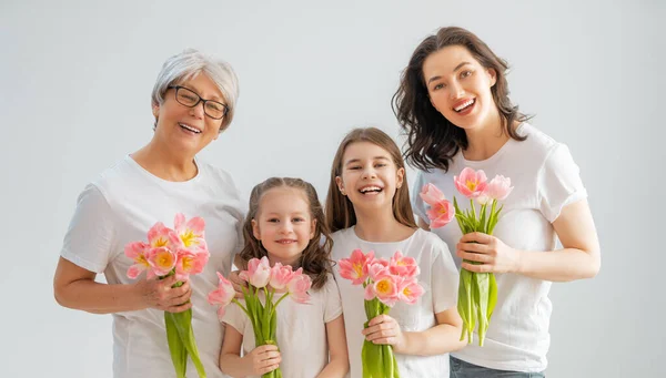 幸せな女性の日 子供たちの娘たちは お母さんとおばあちゃんが花のチューリップを与えてくれることを祝福しています 家族の休日と友情 — ストック写真