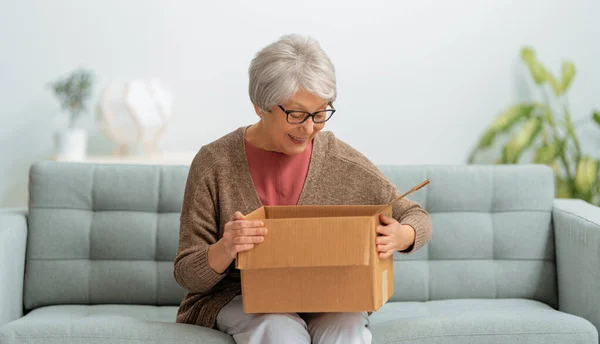 Beautiful Senior Woman Holding Cardboard Box Sitting Sofa Home — Stock Photo, Image