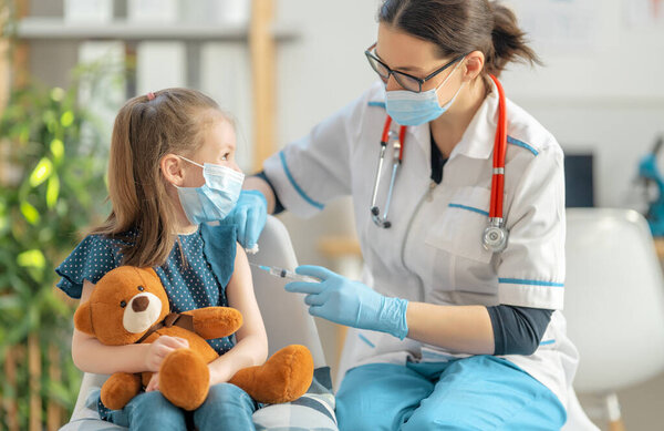 Врач вакцинирует ребенка в больнице.