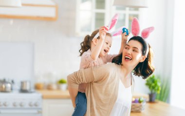 Mutlu aile birlikte fırın hazırlıyor. Anne ve kızı kurabiye pişiriyor ve mutfakta eğleniyorlar. Kız annesine bir buket çiçek veriyor..