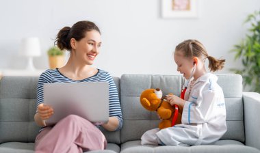 Anneler Günün kutlu olsun! Anne ve kızı oynuyorlar ve gülümsüyorlar. Aile tatili ve birliktelik. 