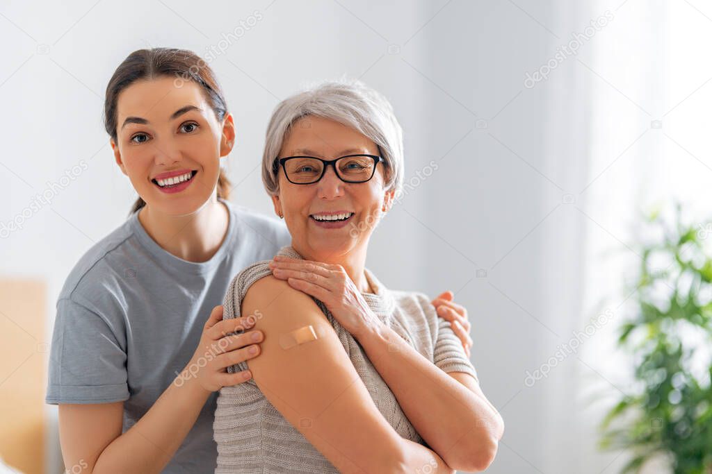 Senior woman after vaccination and her adult daughter at home. Virus protection. COVID-2019.