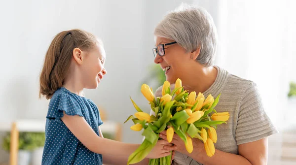 Glücklicher Muttertag Kind Gratuliert Oma Mit Blumen Oma Und Mädchen — Stockfoto