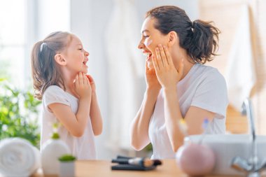 Mutlu aile! Anne ve kızı banyoda cildiyle ilgileniyorlar..