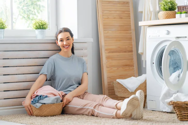 Hermosa Joven Mujer Sonríe Mientras Hace Colada Casa — Foto de Stock