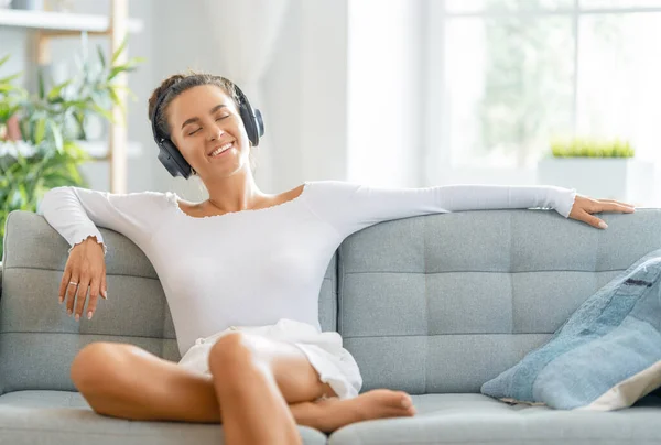 Vrolijke Jonge Vrouw Luisteren Naar Muziek Koptelefoon Zitten Bank Kamer — Stockfoto