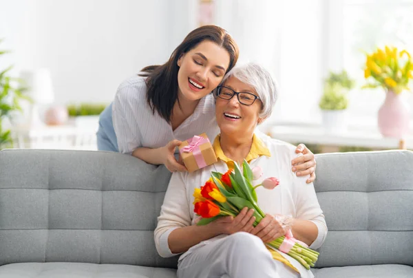 Mooie Jonge Vrouw Haar Moeder Met Bloemen Tulpen Handen Thuis — Stockfoto