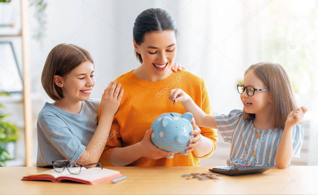 Woman and children sitting at desk with a piggy bank are calculating expenses, managing the family budget.