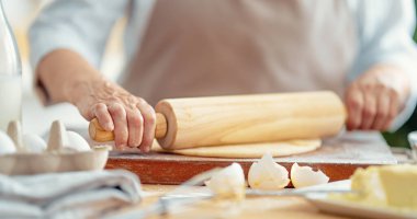 Fırıncının yakın görüntüsü işe yarıyor. Ev yapımı ekmek. Eller ahşap masada hamur hazırlıyor.. 