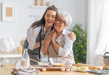 Mutfakta mutlu bir aile. Anne ve yetişkin kızı pasta hazırlıyorlar..