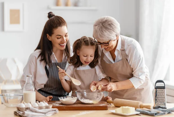 幸せな家族は一緒にパン屋を準備しています おばあちゃん お母さん お子さんがクッキーを作っていて キッチンで楽しんでいます 自家製の食べ物と小さなヘルパー — ストック写真