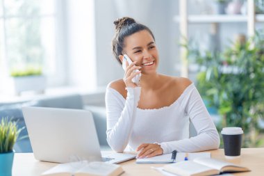 İnternette ders çalışan, Webinar izleyen, dizüstü bilgisayarda podcast yapan notlar alan, çalışma masasında oturan genç bir iş kadını. E-öğrenme kavramı.