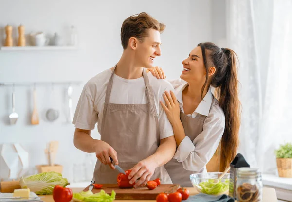 Healthy food at home. Happy loving couple is preparing the proper meal in the kitchen.