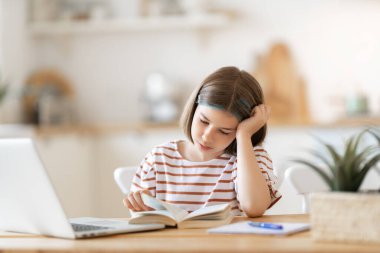 Okula dönelim. Mutsuz çocuk masada oturuyor. Ödev yapan ya da online eğitim alan kız.