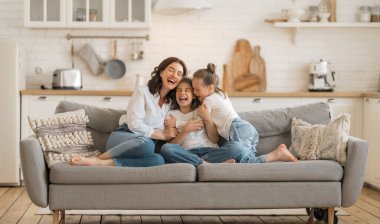 Mutlu bir gün! Anne ve kızları oynuyorlar, gülüyorlar ve sarılıyorlar. Aile tatili ve birliktelik. 