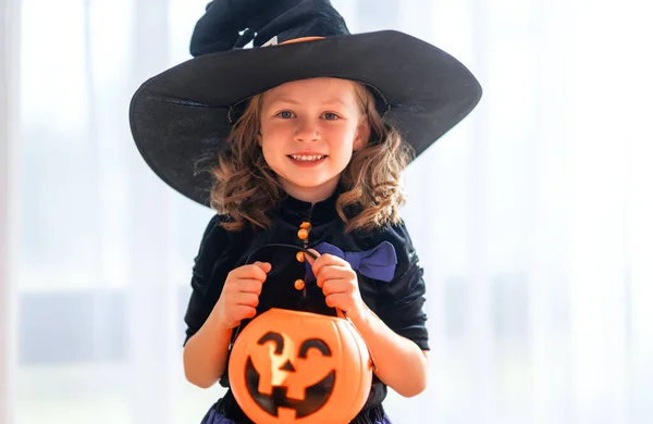 お菓子のためのカボチャのバスケットとかわいい子供 ハロウィーンの準備をしている幸せな女の子 家で面白い子 — ストック写真