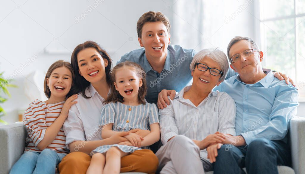 Nice girls, their mother, father, grandfather and grandmother are enjoying spending time together at home. Family time.