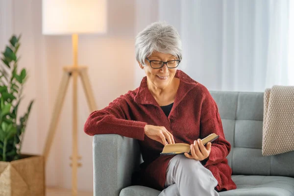 Seniorin Sitzt Auf Dem Sofa Und Liest Hause Zimmer Ein — Stockfoto