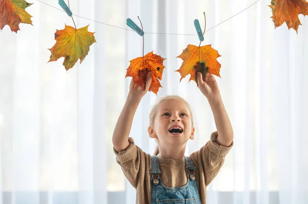Een Kind Dat Een Herfstdecoratie Bloemenslinger Maakt Van Vergeelde Bladeren — Stockfoto