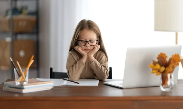 回学校去思考的孩子正坐在办公桌前 做家庭作业或网上教育的女孩 — 图库照片