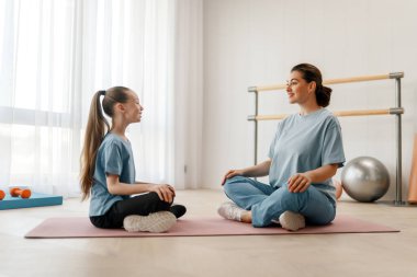 Çocuk fizik tedaviden geçiyor. Kız, doktorun gözetiminde egzersizler yapıyor..