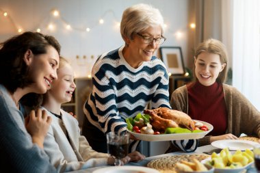 Şükran Günü, Sonbahar ziyafeti. Masada oturup bayramı kutlayan mutlu bir aile. Geleneksel yemek. Büyükanne ve torunlar..  