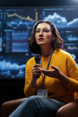 A young woman is giving a presentation at a conference.