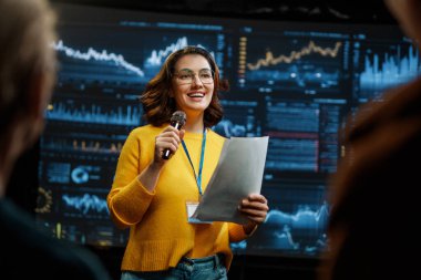 A young woman is giving a presentation at a conference.