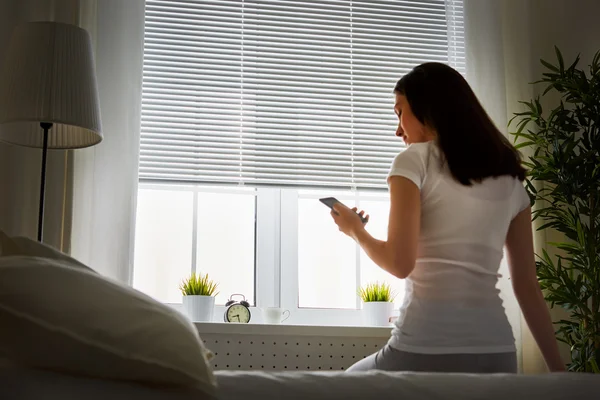 Mujer sentada en la cama — Foto de Stock