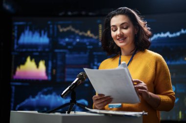 A young woman is giving a presentation at a conference.