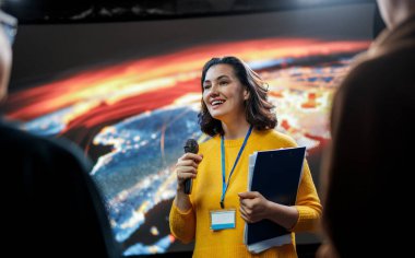 A young woman is giving a presentation at a conference.