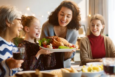 Şükran Günü, Sonbahar ziyafeti. Masada oturup bayramı kutlayan mutlu bir aile. Geleneksel yemek. Büyükanne, anne ve çocuklar. 