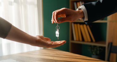 Emlakçı evin anahtarlarını yeni sahibine veriyor. Emlak anlaşması, ipotek kredisi