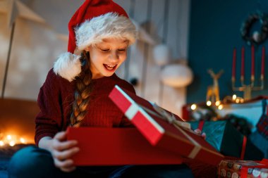 Mutlu Noeller ve mutlu tatiller. Hediyesi olan neşeli, sevimli bir kız çocuğu. Çocuk eğleniyor..    