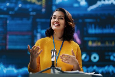 A young woman is giving a presentation at a conference.