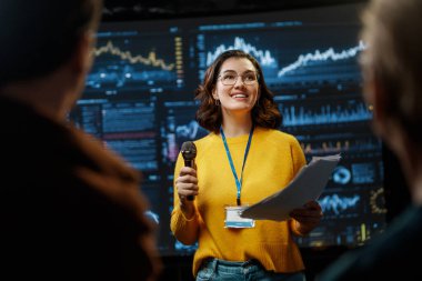 A young woman is giving a presentation at a conference.