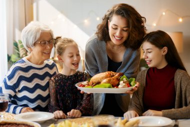 Şükran Günü, Sonbahar ziyafeti. Masada oturup bayramı kutlayan mutlu bir aile. Geleneksel yemek. Büyükanne, anne ve çocuklar. 