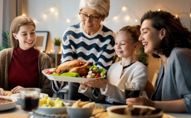 Şükran Günü, Sonbahar ziyafeti. Masada oturup bayramı kutlayan mutlu bir aile. Geleneksel yemek. Büyükanne, anne ve çocuklar. 
