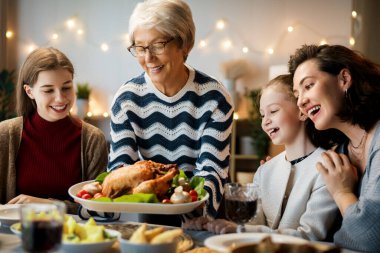 Şükran Günü, Sonbahar ziyafeti. Masada oturup bayramı kutlayan mutlu bir aile. Geleneksel yemek. Büyükanne, anne ve çocuklar. 